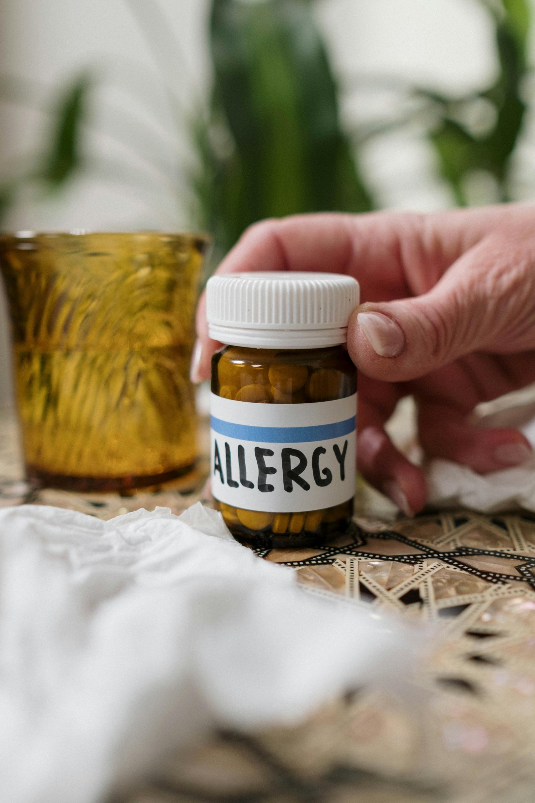 Photo by cottonbro studio | Motherhues Close-up of allergy medication bottle with tissues and amber glass indoors.
