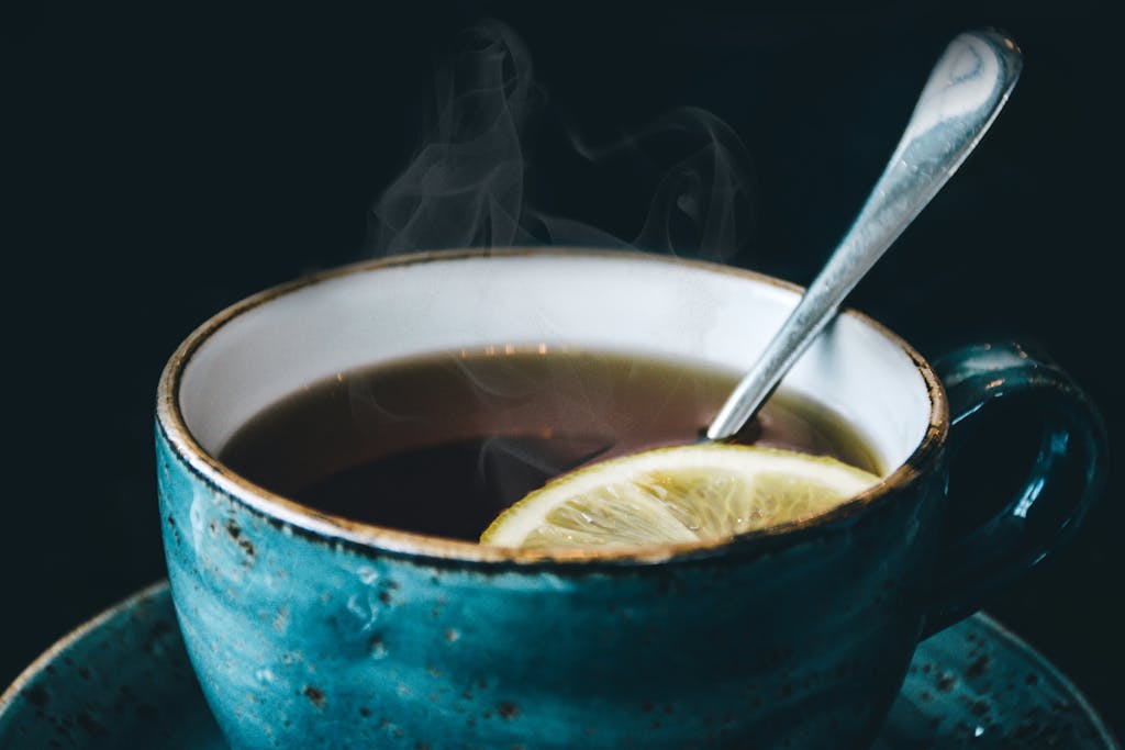 Photo by Lisa Fotios | Motherhues Close-up of aromatic steaming lemon herbal tea served in a ceramic cup with saucer.