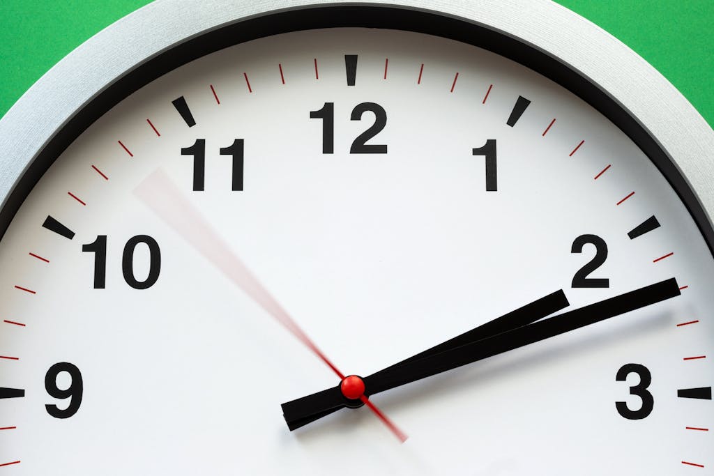 Photo by Stas Knop | Motherhues A close-up image of an analog clock face showing time with blurred motion: schedule