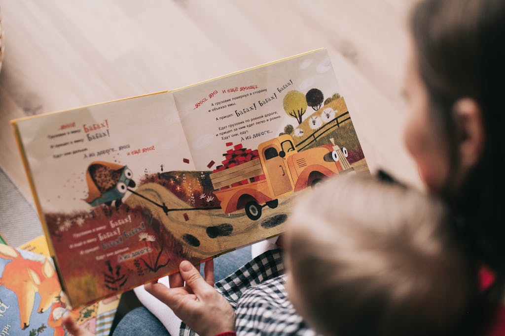 Photo by Lina Kivaka | Motherhues A mother and toddler sharing a story from an illustrated children's book indoors.