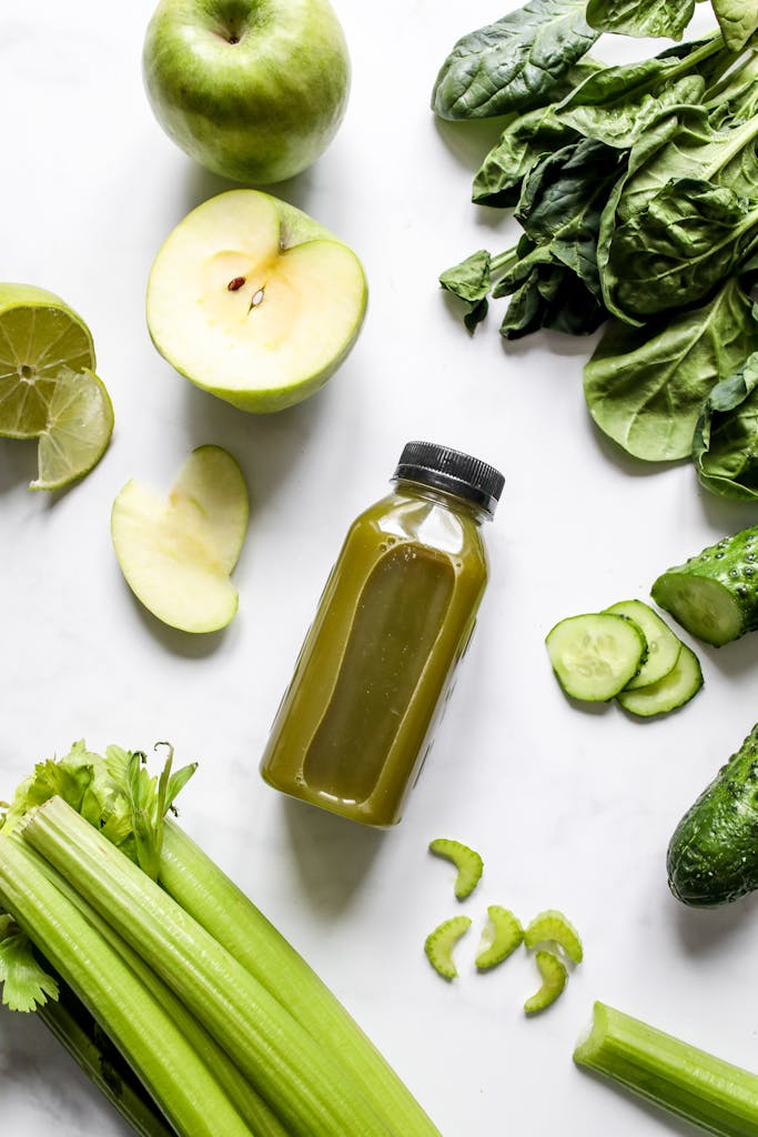 Photo by Polina Tankilevitch | Motherhues Flatlay of fresh green juice with vegetables and fruits on a white background, perfect for healthy lifestyle concepts.