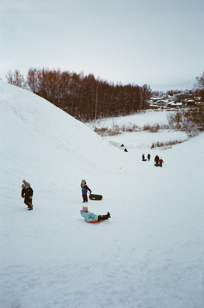 Photo by Polina Chistyakova | Motherhues Children enjoying winter sledding on a snow-covered hill in Suzdal, Russia.