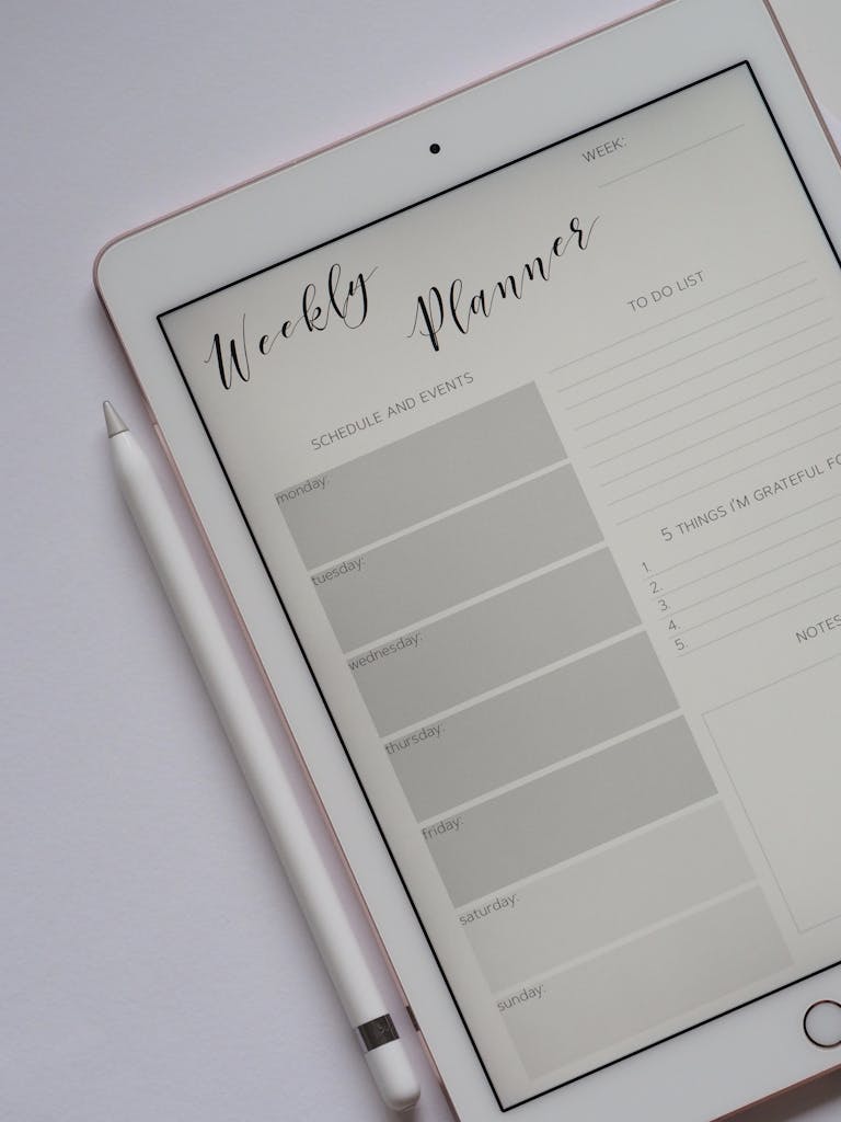 Photo by Jess Bailey Designs | Motherhues Close-up of a digital weekly planner displayed on a tablet with stylus.