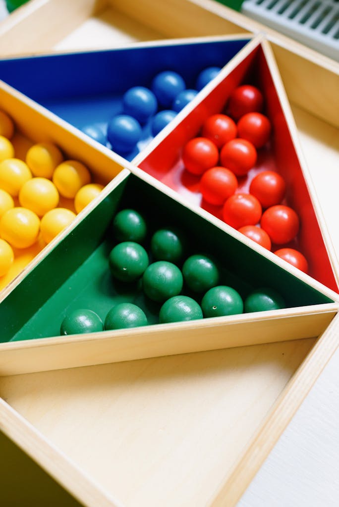 Photo by Ksenia Chernaya | Motherhues Close-up of colorful balls arranged in a triangular wooden toy, ideal for educational games.