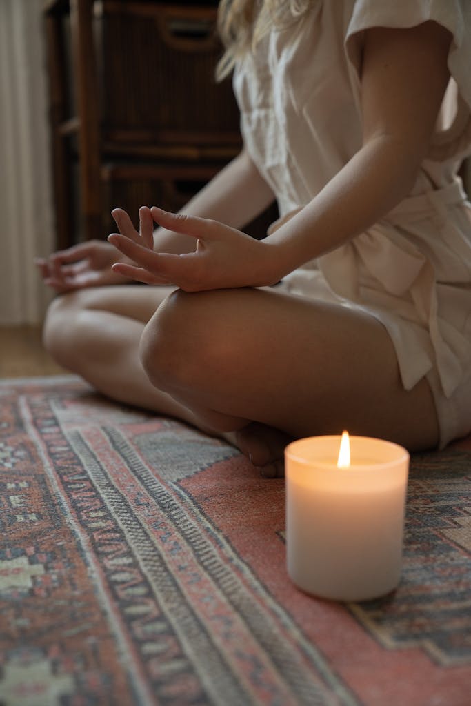 Photo by Kevin Malik | Motherhues Experience tranquility with a lit candle and meditative pose, ideal for mindfulness practices after holiday chaos.