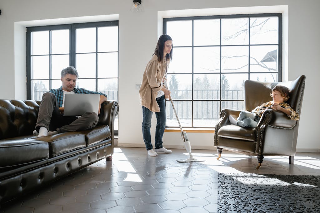 Photo by MART PRODUCTION | Motherhues Family scene depicting vacuuming, working, and relaxing in cozy living room with natural light.