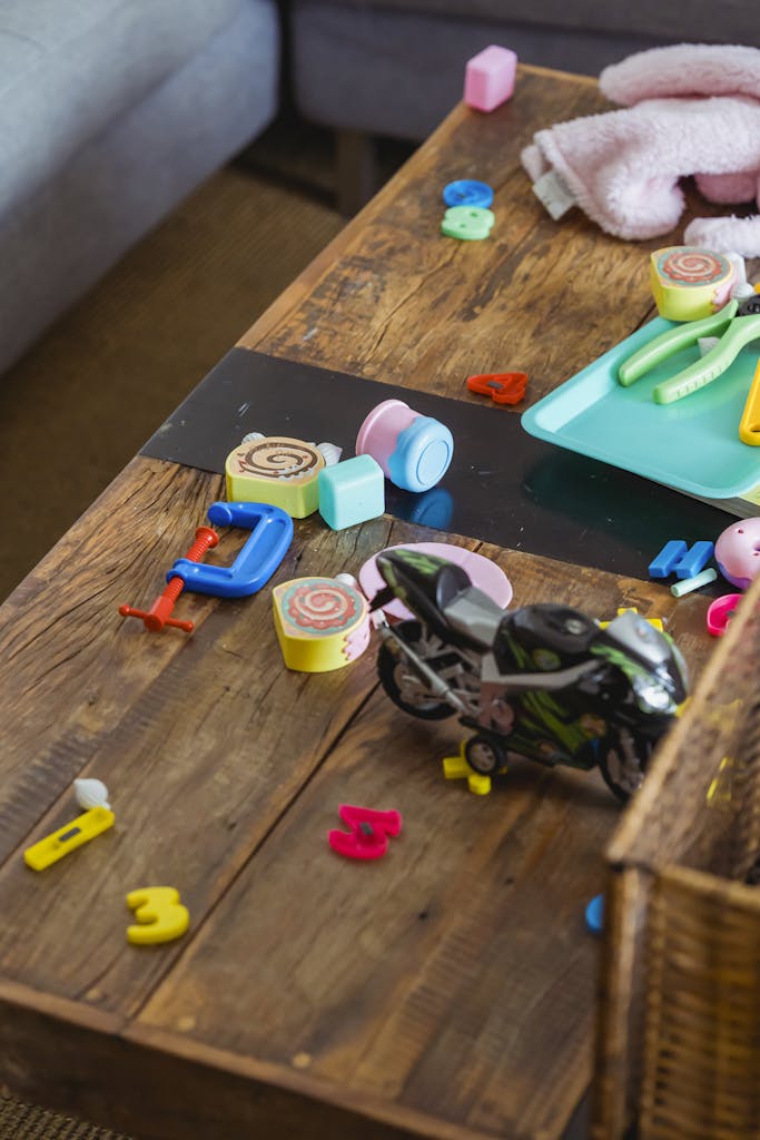 Photo by Keira Burton | Motherhues From above of toy mess on desk near gray sofa after children playing game after holidays